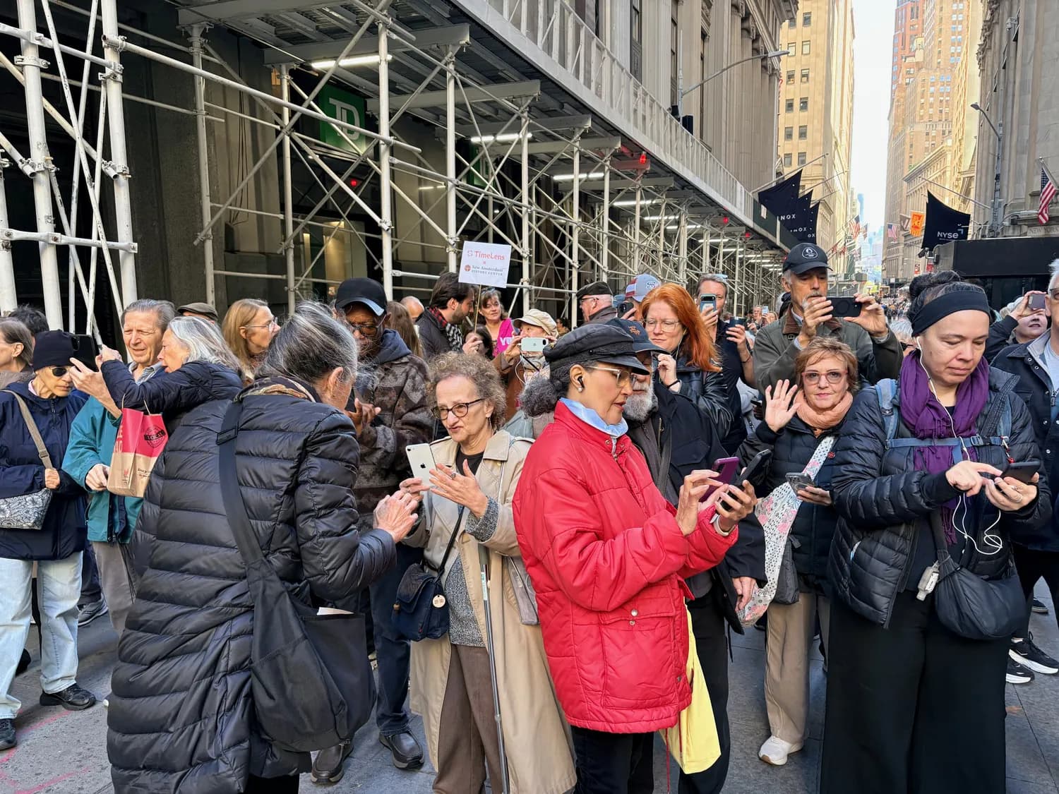 Eine Menge von Guides und Besuchern an der Wall Street hält die Smartphones hoch, um Neu-Amsterdam in TimeLens zu sehen